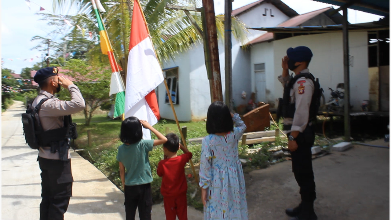 SAMBUT HUT RI YANG KE 77, PERSONEL BATALYON C BRIMOB KALTIM BAGIKAN BENDERA MERAH PUTIH KEPADA MASYARAKAT
